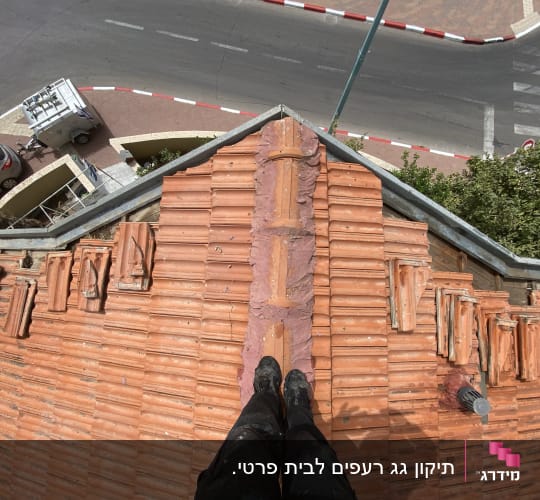 רעפים כתומים על גג עם צינור מתכת